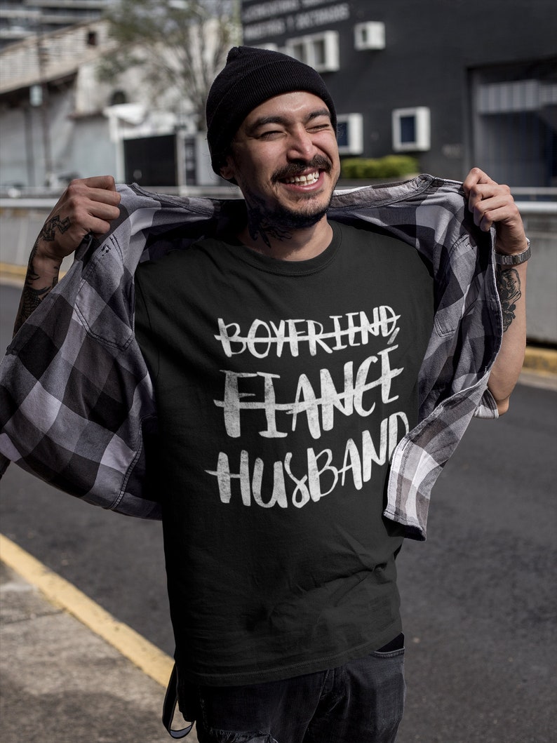 May include: A black t-shirt with white text that reads "Boyfriend Fiance Husband".