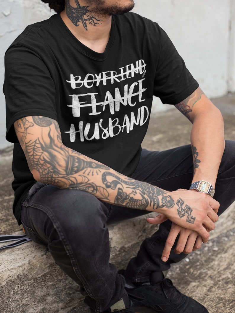 May include: A black t-shirt with white text that reads "Boyfriend Fiance Husband".