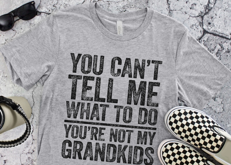 May include: Gray t-shirt with a black distressed graphic that reads "You can't tell me what to do you're not my grandkids".