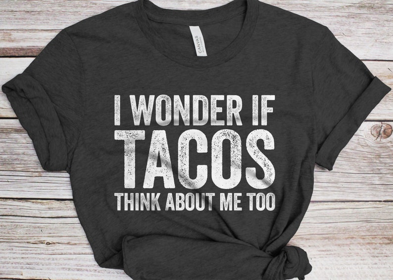May include: A dark gray t-shirt with the text "I wonder if tacos think about me too" printed in white.