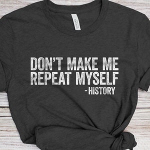 May include: A dark gray t-shirt with the text "Don't make me repeat myself - History" printed in white.