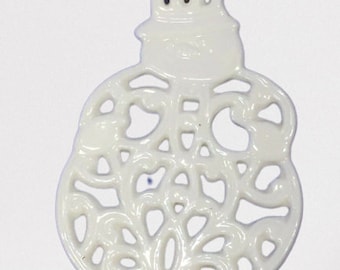 May include: White porcelain Christmas ornament shaped like a snowman with a lacy design. The ornament has a red ribbon attached to the top.