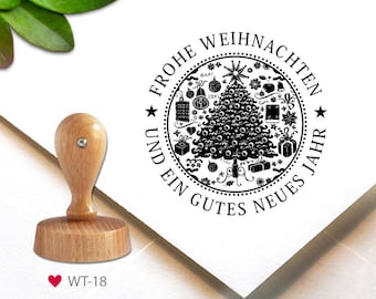 May include: A black and white rubber stamp with a Christmas tree design. The stamp reads "Frohe Weihnachten und ein gutes neues Jahr" which translates to "Merry Christmas and a Happy New Year".