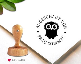 May include: A wooden stamp with a handle and a round base, next to a stamped image of a black owl with the text "ANGESCHAUT VON FRAU SOMMER". The stamp is on a white surface. The text "Motiv 492" is below the stamp.