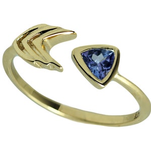 Może przedstawiać: Złoty pierścionek o unikalnym wzorze. Pierścionek posiada trójkątny, niebieski kamień szlachetny oraz otwarty design z zakrzywionym, warstwowym elementem. Pierścionek jest umieszczony na białym tle, podkreślając jego skomplikowane detale.