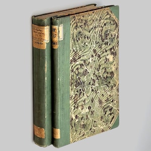 May include: Two antique green books with marbled covers. The spines are labeled with handwritten text, including "1845" and "Principe Italiano del secolo decimo settimo".