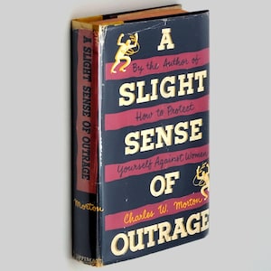 May include: A book titled "A Slight Sense of Outrage" by Charles W. Morton. The book cover is black with gold lettering and a red and gold design. The book is about how to protect yourself against women.