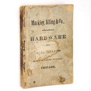 Könnte beinhalten: Ein alter, abgenutzter Buchumschlag mit dem Titel "Markley, Alling & Co., Wholesale Hardware and Cutlery, 50 and 55 Lake Street, Chicago."