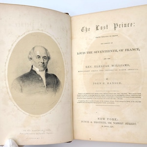 May include: The cover of a book titled "The Lost Prince: Facts tending to prove the Identity of Louis the Seventeenth, of France, and the Rev. Eleazar Williams, Missionary among the Indians of North America, by John H. Hanson." The cover features a black and white portrait of a man with a white collar and a dark coat.