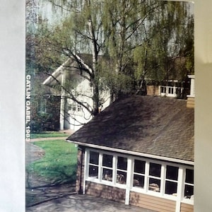 May include: A view of a house with a brown shingled roof and a large window. The house is surrounded by trees and a grassy area. The text "CATLIN GABEL 1983" is printed on the side of the image.