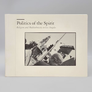 Può includere: Una fotografia in bianco e nero della copertina di un libro intitolato "Politics of the Spirit: Religion and Multiethnicity in Los Angeles". La copertina presenta una foto di due persone che parlano per strada davanti a una chiesa.