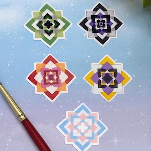 Puede incluir: Una colección de pegatinas de flores geométricas coloridas en verde, morado, naranja, amarillo y azul. Un pincel con mango rojo y férula dorada está en la esquina inferior izquierda. Las pegatinas están sobre un fondo azul claro con motas blancas.