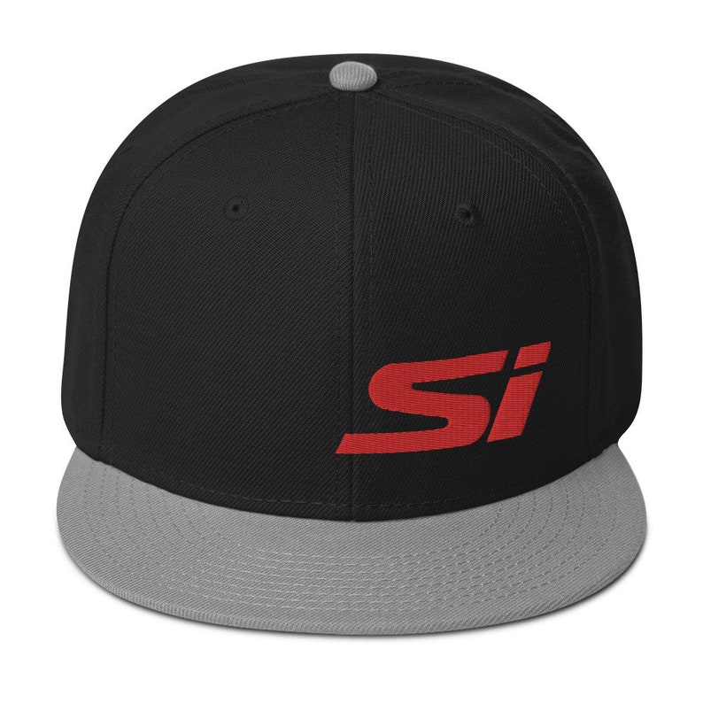 May include: Black and gray flat-brimmed baseball cap with the red letters "SI" embroidered on the front. The cap has a gray brim and a gray button on top.