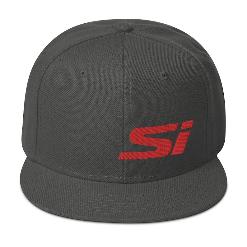 May include: A charcoal gray flat-brimmed baseball cap with the red letters "SI" embroidered on the side. The cap has a structured fit and a flat visor. The hat is a classic style, suitable for casual wear.