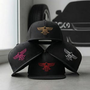 May include: A white ceramic mug with a black handle and the text "But First, Coffee" in a black, handwritten-style font. The mug is on a white surface.