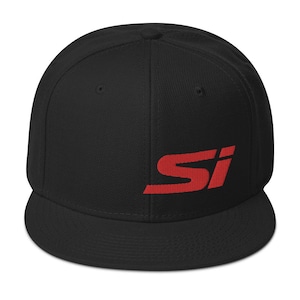 May include: Black flat-brimmed baseball cap with the red letters "SI" embroidered on the front. The cap has a structured fit and a curved brim. The hat is a classic style.