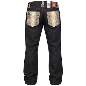 May include: Dark charcoal denim jeans featuring back pockets and belt loops with a snakeskin pattern. The garment includes red contrast stitching, a brown leather patch with a silver logo, and a white tag with the letters GG on the waistband.