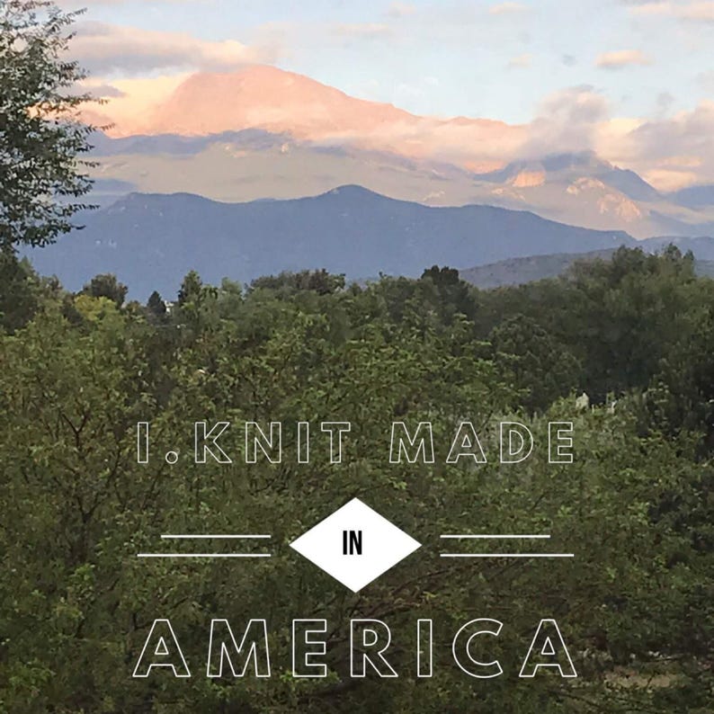 以下が含まれることがあります： 曇り空の山の景色。画像に「I.KNIT MADE IN AMERICA」というテキストが重ねられています。