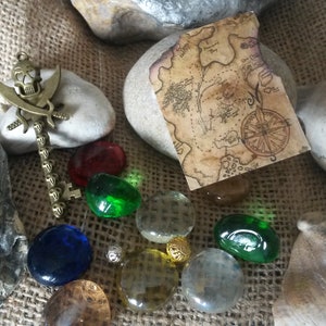 Trésor de pirate avec petite carte, bijoux en verre et clé tête de mort en métal