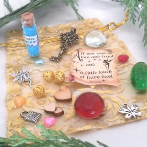 May include: A gold pouch with a variety of charms and trinkets, including a small bottle of blue glitter, a key, a heart, a butterfly, and a scroll with the text "All you need is love and trust and a little touch of fairy dust".