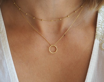 Lot de deux colliers superposés, un collier double, un pendentif cercle Karma et une chaîne satellite