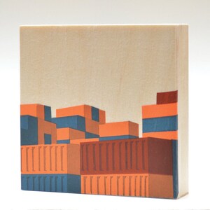 May include: A wood block art print with a geometric design of a building with orange, brown, and blue colors.