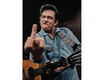 May include: A sticker featuring a portrait of a man in a denim shirt, holding a guitar and giving the middle finger. The man has dark hair and is wearing a ring. The guitar is brown and has a black strap.