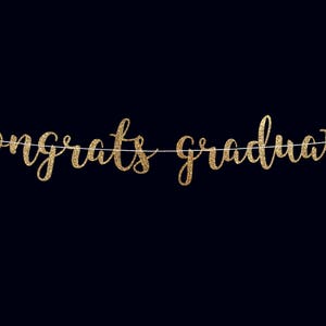 Peut inclure: Banni&egrave;re dor&eacute;e &agrave; paillettes avec le texte "Congrats Graduate" suspendue &agrave; une ficelle blanche sur un fond noir.