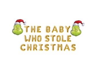 May include: Gold foil letter balloons spelling "THE BABY WHO STOLE CHRISTMAS" with two green Grinch character balloons wearing Santa hats on either side.