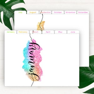 May include: A set of printable monthly calendar dividers with a glittery rainbow watercolor design and the word "January" written in black cursive. The dividers are labeled with the months of the year, including January, February, March, April, May, June, July, August, September, October, November, and December.
