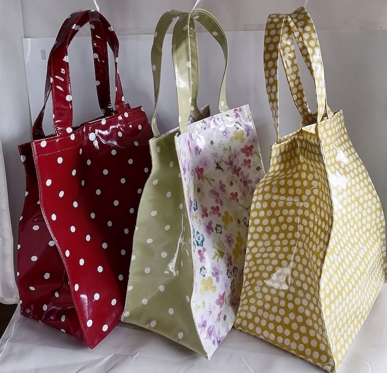 Peut inclure: Quatre sacs fourre-tout brillants. Un rouge &agrave; pois blancs, un vert olive &agrave; pois blancs, et un dor&eacute; &agrave; pois blancs. Le quatri&egrave;me pr&eacute;sente un motif floral. Tous ont des anses assorties.
