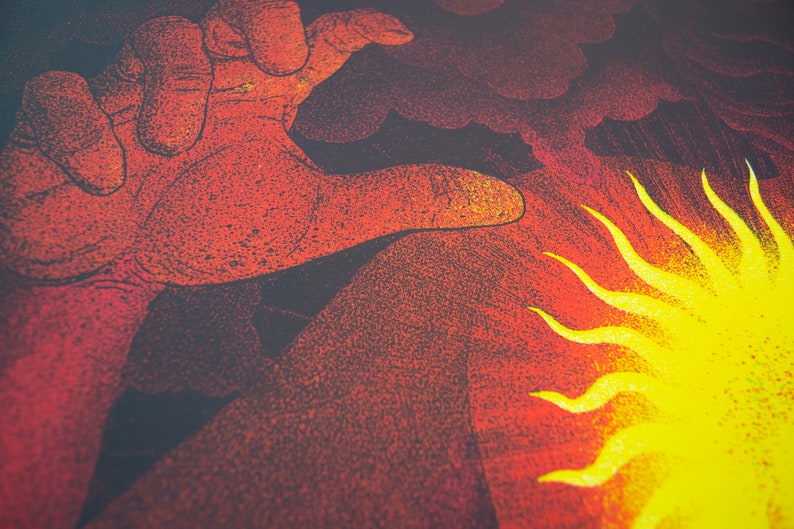 Op de afbeelding: Een close-up van een hand die reikt naar een gele zon met rode en zwarte wolken op de achtergrond.