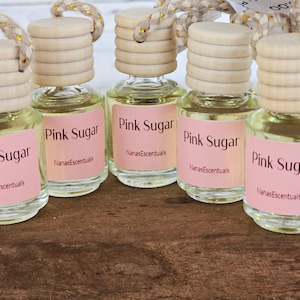 May include: Five small glass bottles with wooden stoppers and pink labels that say "Pink Sugar" and "NanasEscentuals".