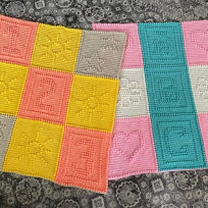 Peut inclure: Deux couvertures pour bébé en crochet avec différentes combinaisons de couleurs et motifs. Une couverture présente un motif soleil, cœur et étoile en jaune, orange et gris. L'autre couverture présente un motif soleil, cœur et étoile en turquoise, rose et blanc.
