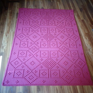 May include: A pink crocheted throw blanket with a geometric pattern.