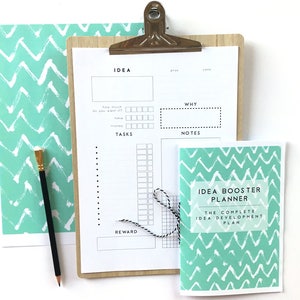 May include: A teal and white chevron patterned planner with the title "Idea Booster Planner: The Complete Idea Development Plan".
