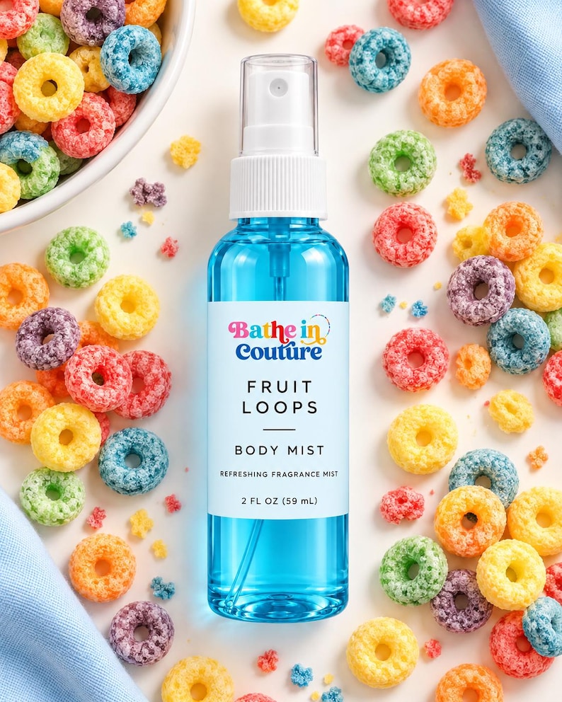 May include: A clear plastic spray bottle filled with blue liquid, featuring a white label that reads Bathe in Couture FRUIT LOOPS BODY MIST 2 FL OZ (59 mL), surrounded by scattered colorful ring-shaped cereal pieces on a white surface.