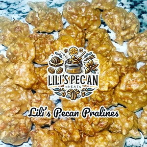 May include: A collection of golden-brown pecan pralines with a glossy, caramelized coating. Centered is a logo with the text Lili's Pecan Treats and the phrase Lili's Pecan Pralines below, featuring illustrations of nuts and a jar.