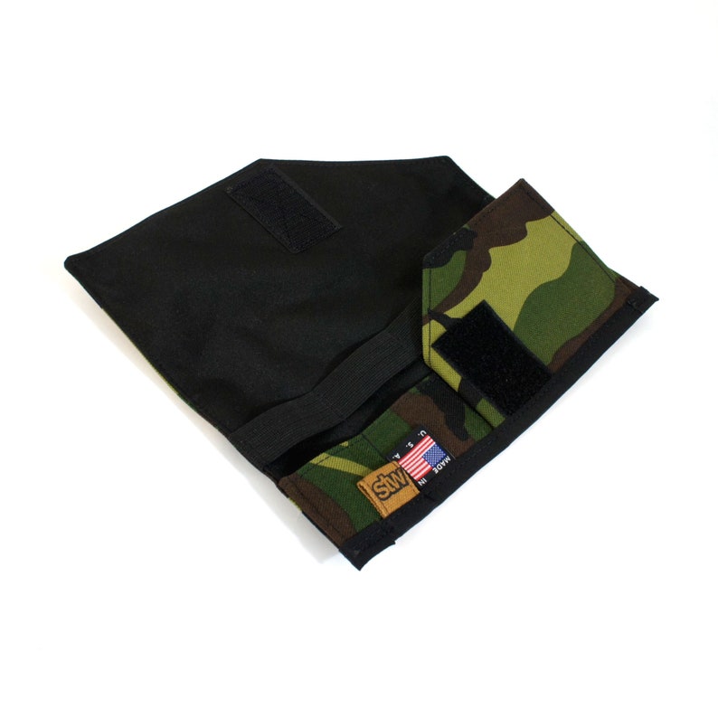 Op de afbeelding: Een zwarte en camouflage stoffen portemonnee met een klittenbandsluiting en een klein Amerikaans vlagpatch met de tekst "Made in USA".