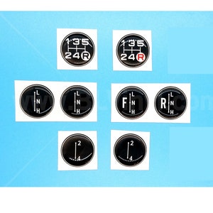May include: Set of eight black and white gear shift knob stickers. The stickers feature different gear shift patterns, including 1-3-5, 2-4-R, L-N-H, F-N-H, R-N-H, and 1-2-4.