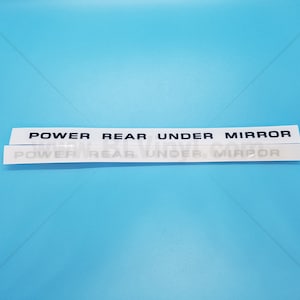 以下が含まれることがあります： 「POWER REAR UNDER MIRROR」と黒文字で書かれた白いステッカーです。