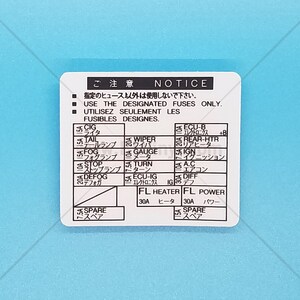 May include: A white fuse box diagram with Japanese and English text. The diagram shows the location of fuses for various car components, including the cigarette lighter, tail lights, fog lights, stop lights, defogger, wiper, gauge, turn signal, rear heater, ignition, air conditioning, differential, and spare fuses. The diagram also includes the amperage rating for each fuse.