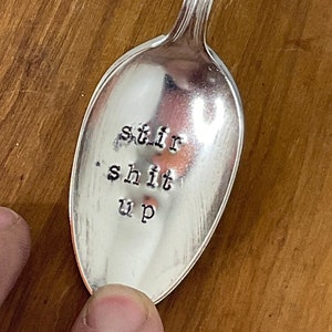 以下が含まれることがあります： 「stir shit up」と刻まれた銀のスプーン