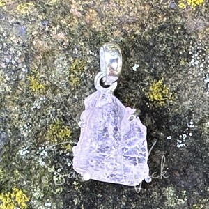 aa+ quality genuine pink kunzite set in sterling silver resting atop a rock