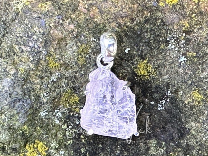 aa+ quality genuine pink kunzite set in sterling silver resting atop a rock