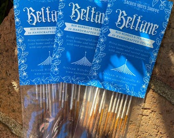 May include: Three packages of incense sticks with blue and white labels. The labels say "Sacred Mists Shoppe" and "Beltane" with the text "Red Berries & Tea Rose 10 Handcrafted Sticks".