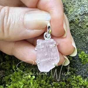 pink kunzite aa+ quality natural nugget pendant set in sterling silver held against fingers to show the texture and size of the raw pink kunzite stone