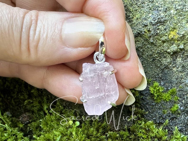 pink kunzite aa+ quality natural nugget pendant set in sterling silver held against fingers to show the texture and size of the raw pink kunzite stone