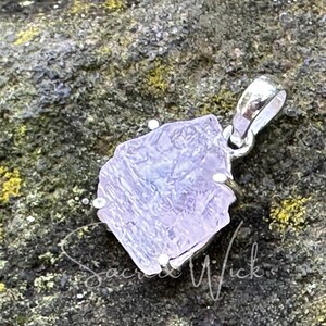 aa+ quality pink kunzite nugget pendant set in sterling silver sitting at an angle to show the texture and shape of the all-natural kunzite aa+ raw stone