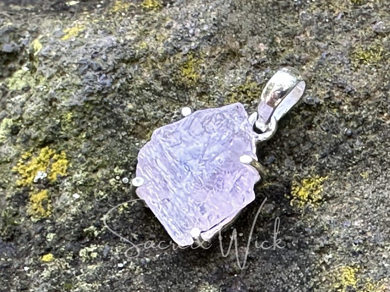 aa+ quality pink kunzite nugget pendant set in sterling silver sitting at an angle to show the texture and shape of the all-natural kunzite aa+ raw stone